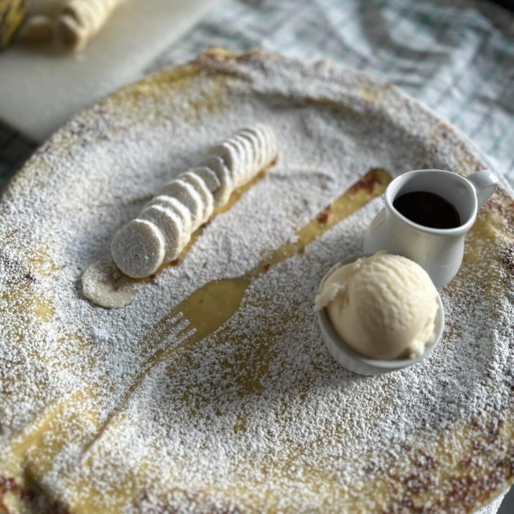 Pannenkoek met ijs, suiker, chocolade saus en banaan. Verkocht product in de Koekedoze in Gullegem. ( Eet en drinkgelegenheden in de Grensleie streek)